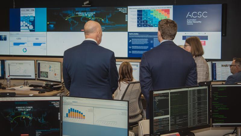 An Australian cyber operations centre or SOC environment with analysts monitoring large digital displays