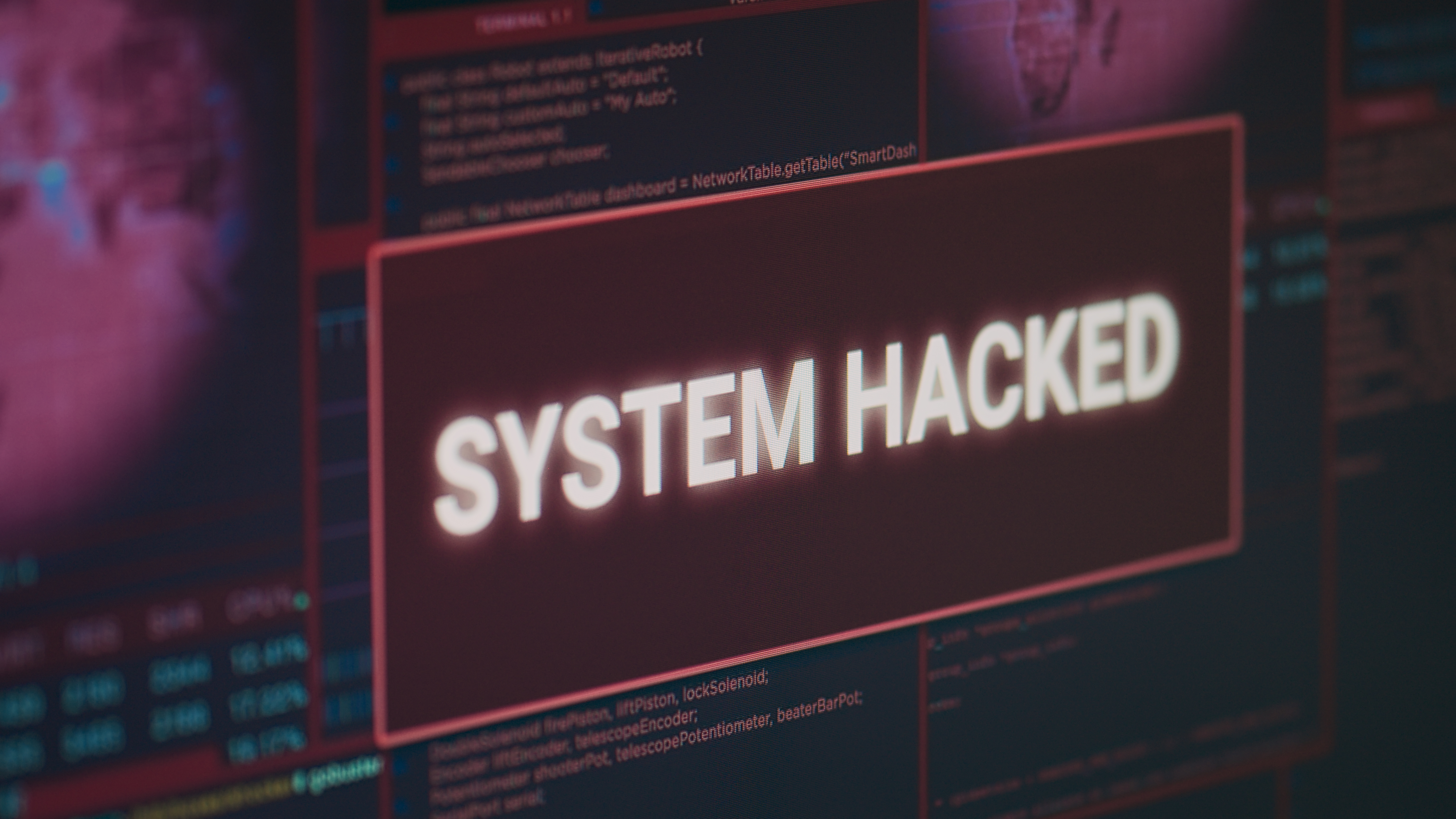 Computer monitor showing hacked system alert message flashing on screen, dealing with hacking and cyber crime attack.