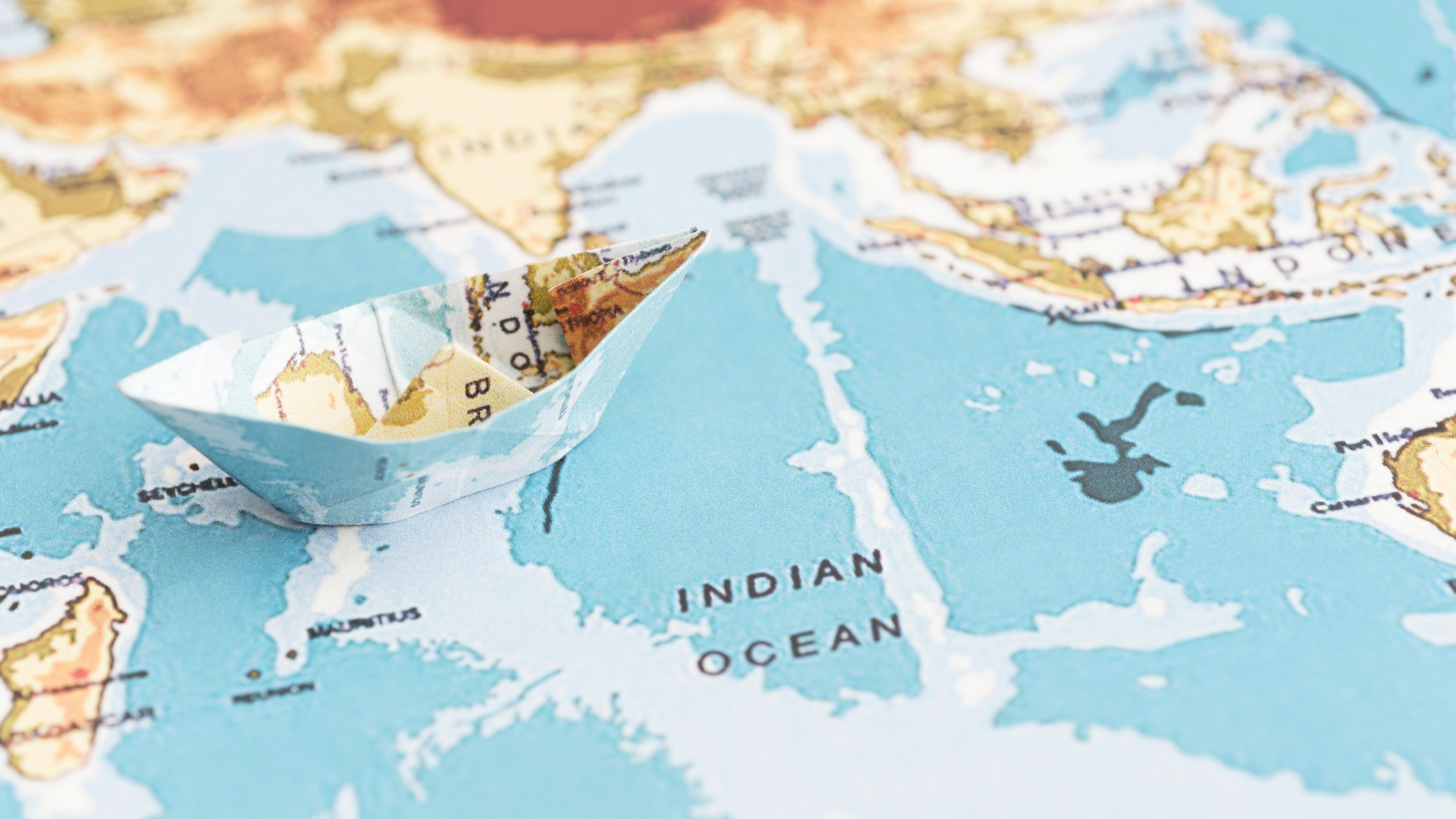 paper boat on world map