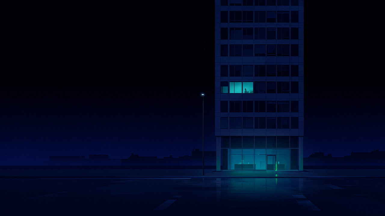 A dark office building at night with only the reception and one monitoring room window lit